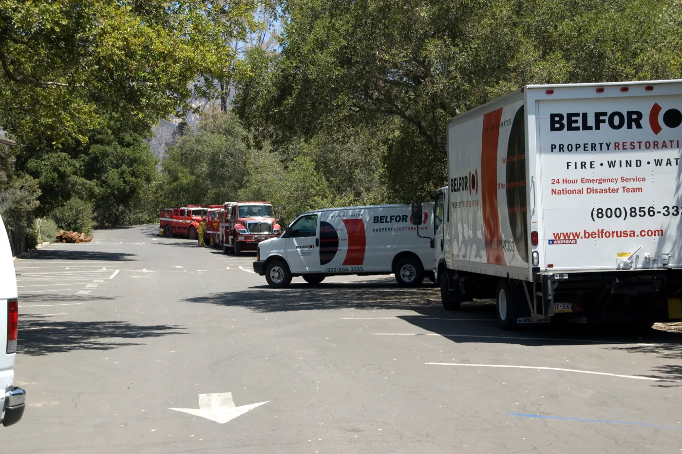 fire trucks and Balfor insurance trucks in the parking lot, after the Jesusita Fire