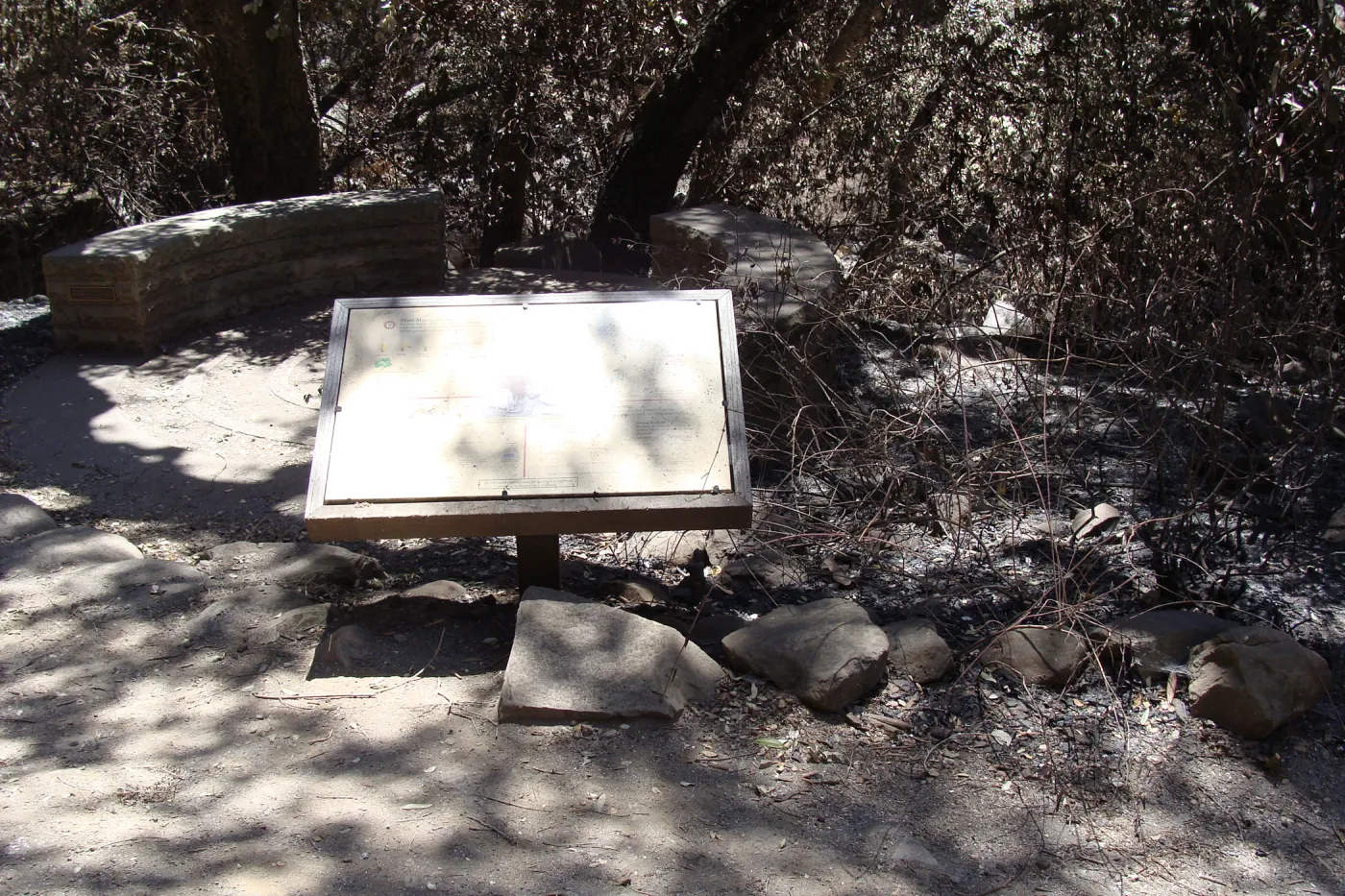 Fiber Arts Display sign, with spiral patio and circular stone bench, after the Jesusita Fire