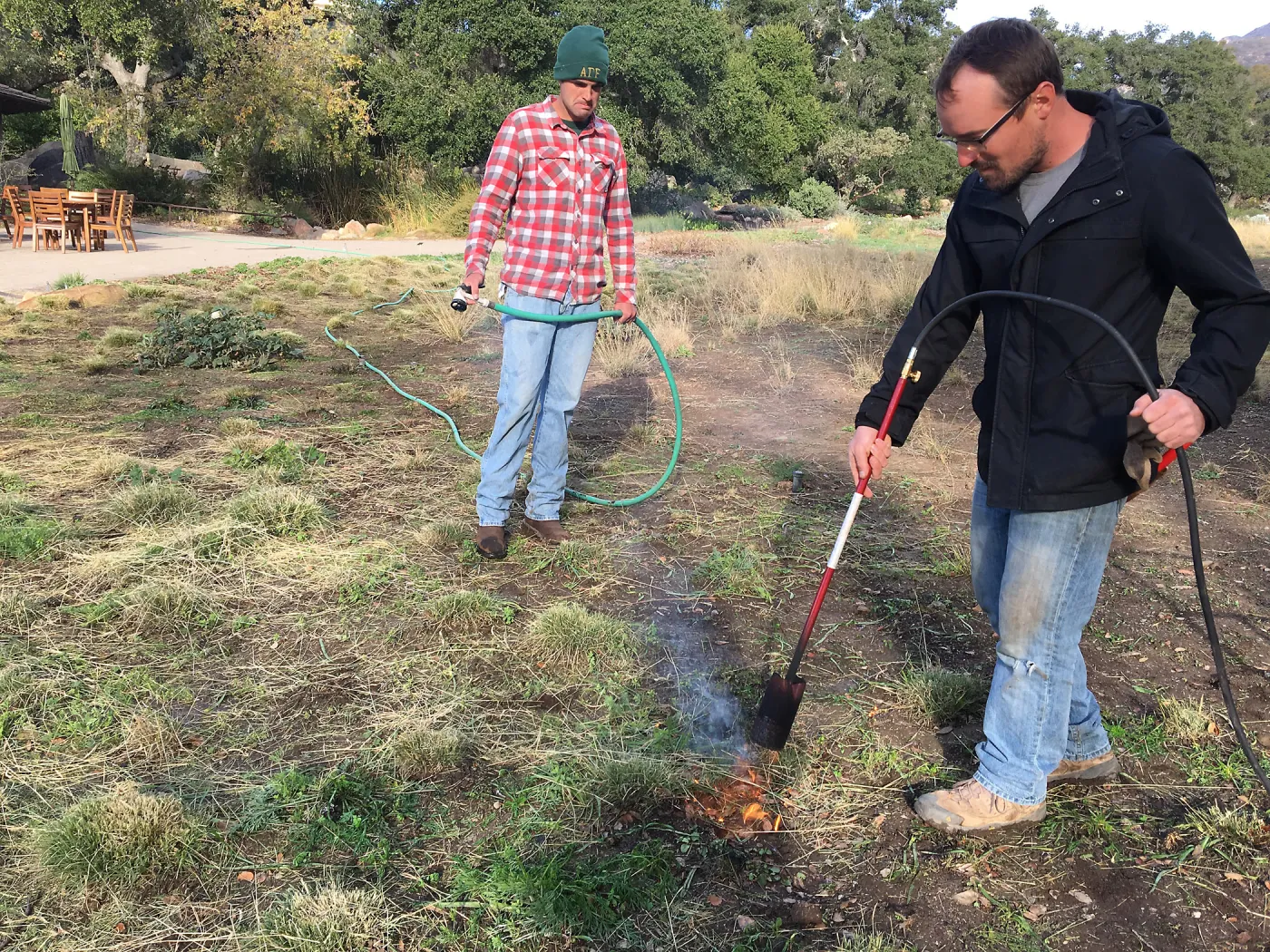 Wes Franken and Nick Resler using a torch for weed abatement