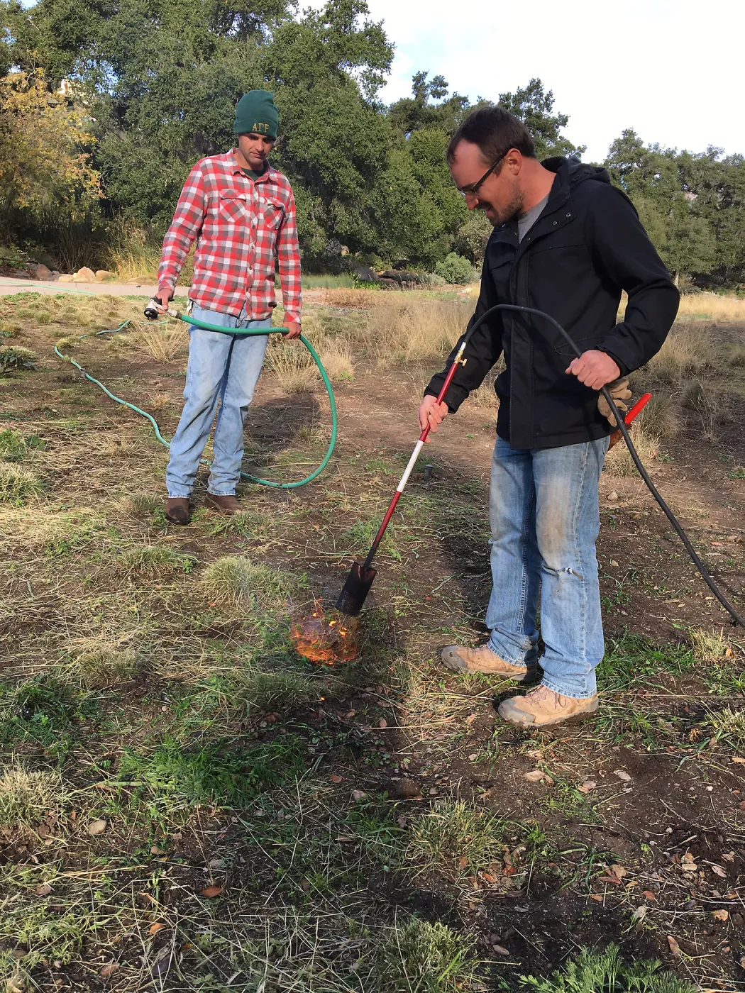 Wes Franken and Nick Resler using a torch for weed abatement