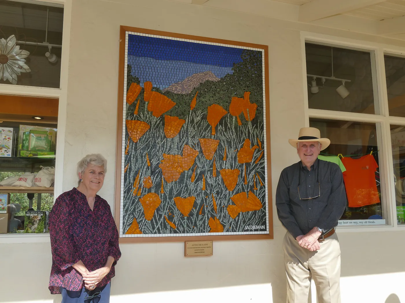 Suzanne and Duncan Mellichamp with â€œAfter the Rainsâ€ mosaic by Patti Jacquemain