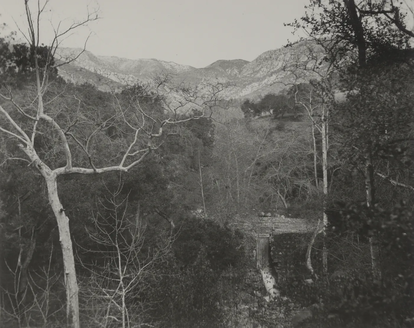 view of Mission Dam and Mission Creek waterfall with mountains behind, circa 1942