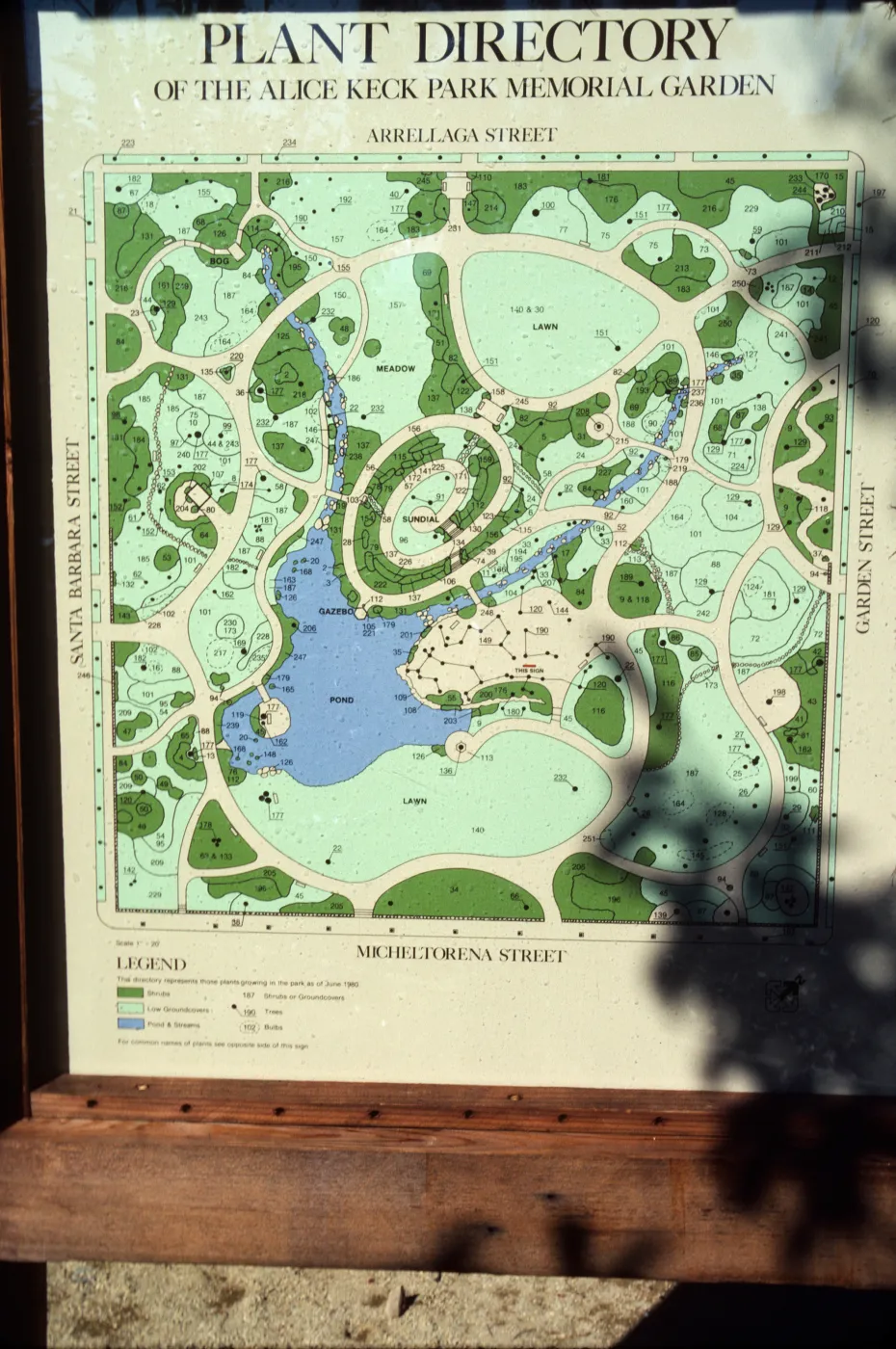An outdoor map in a wooden frame titled "Plant Directory of the Alice Keck Park Memorial Garden."