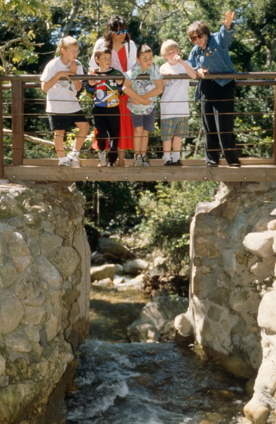 visitors stand on the foot bridge on the Mission Dam