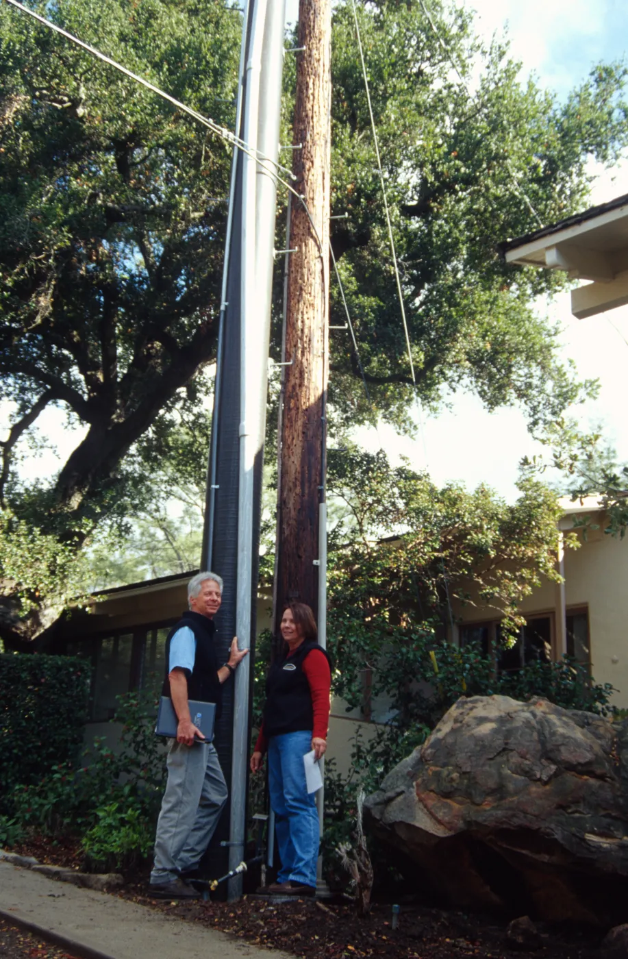 New power pole installed adjacent to the old wooden 'acorn granary' pole