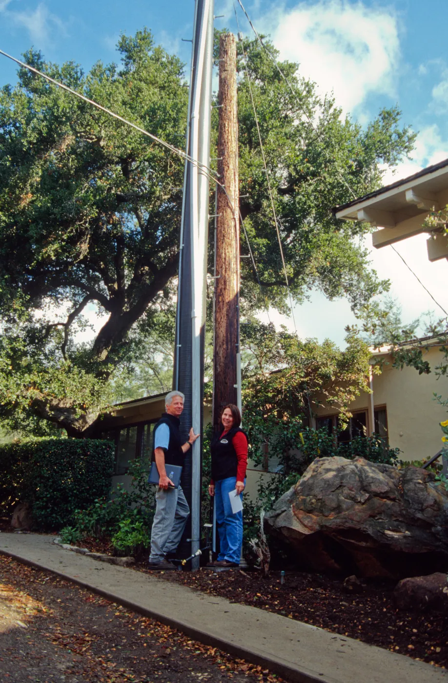 New power pole installed adjacent to the old wooden 'acorn granary' pole