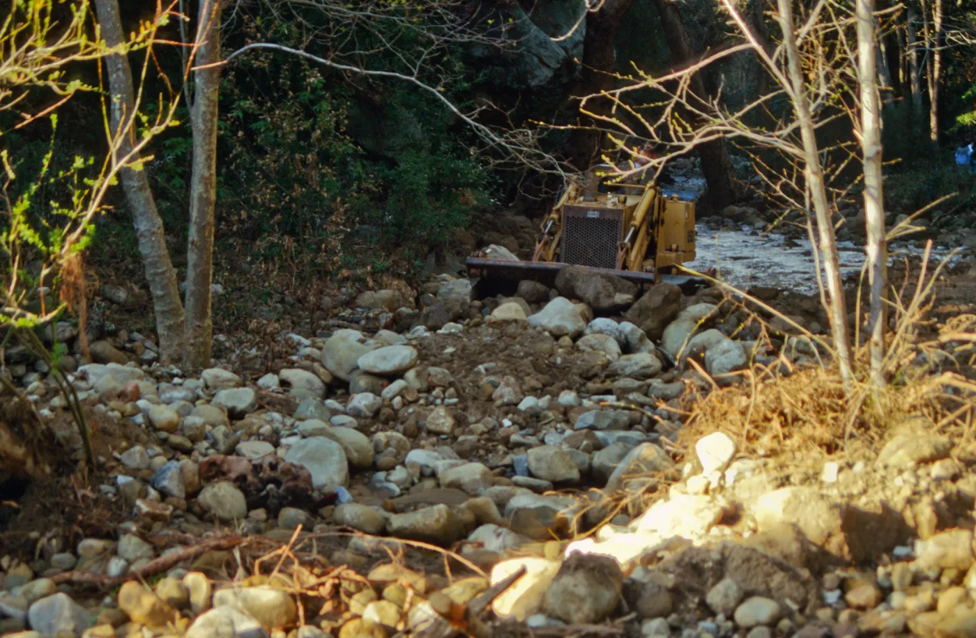Mission Creek flooded above Mission Dam, with a bulldozer in background