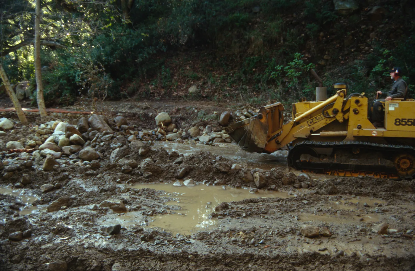 Mission Creek flooded above Mission Dam, with a bulldozer