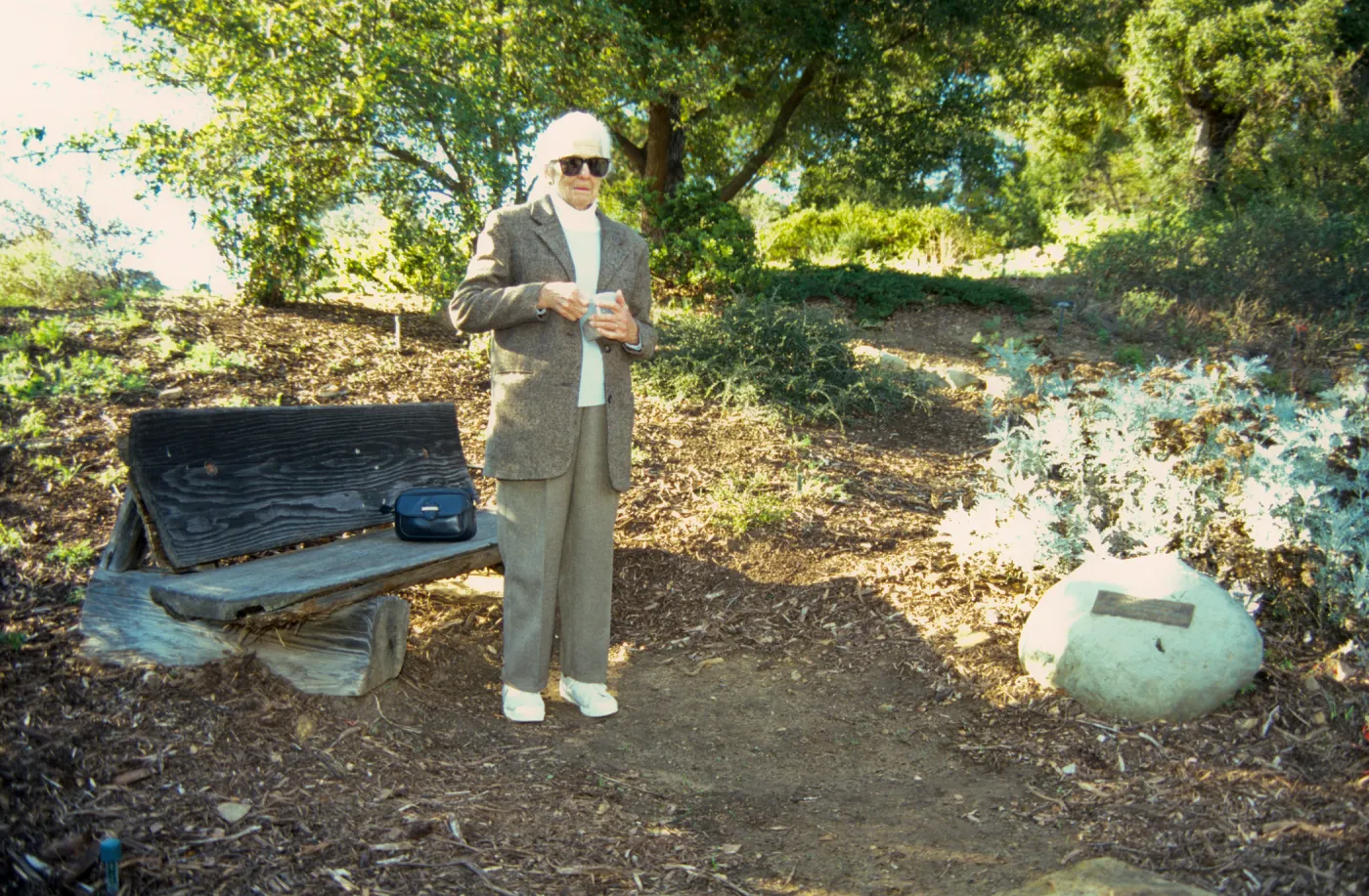 Ann Jones sowing wildflower seeds, Porter Trail, wood bench