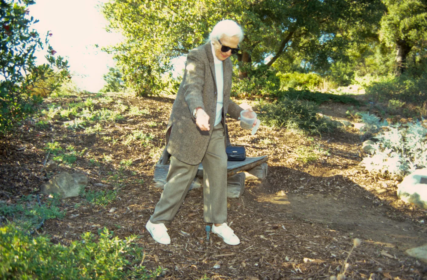 Ann Jones sowing wildflower seeds, Porter Trail, wood bench