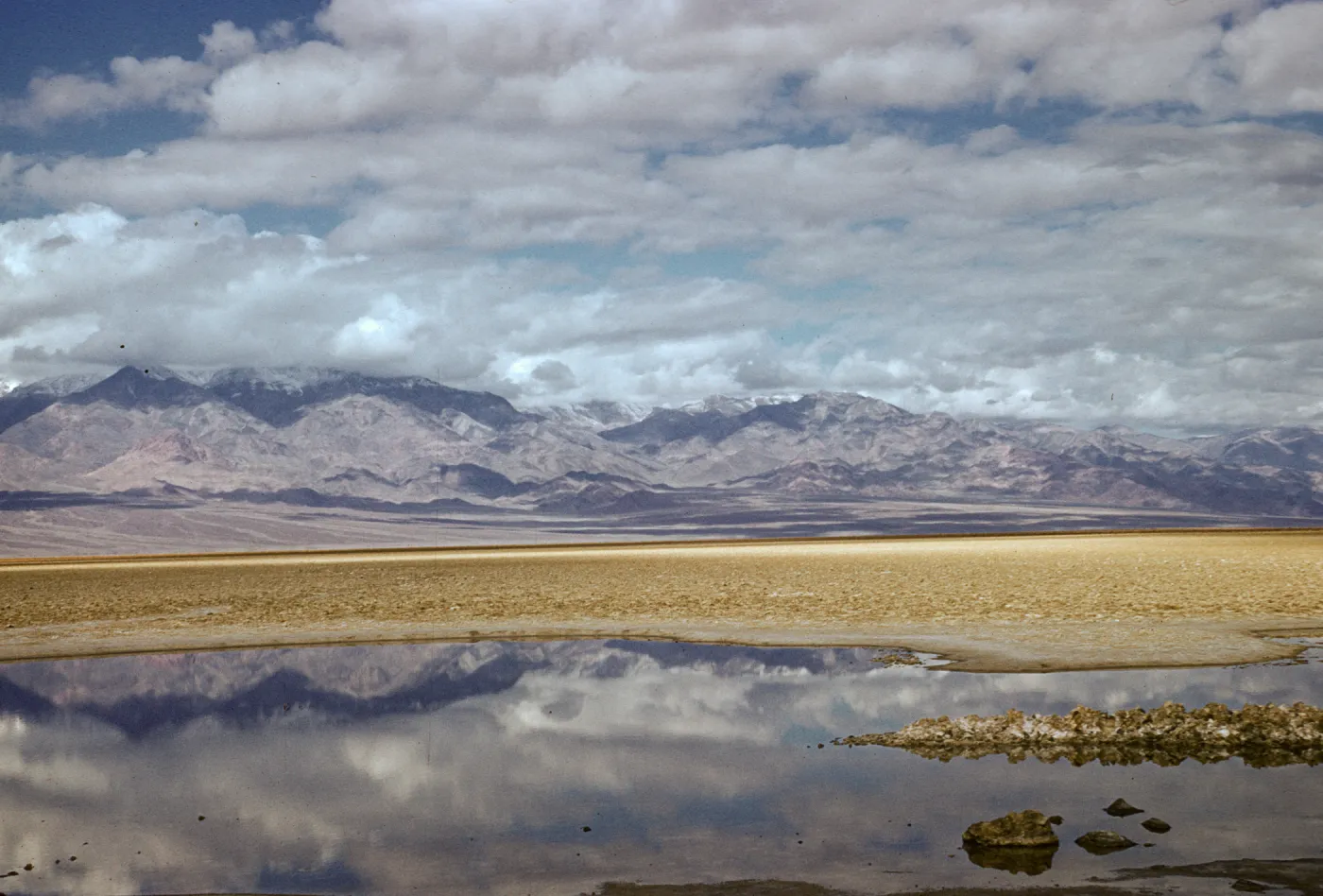 Badwater, mountains and clouds reflected in high desert pool