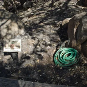 Santa Barbara Botanic Garden after the Jesusita Fire, melted hose, burned No Smoking Allowed sign