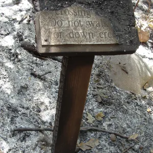 ash and fire debris, burned wood sign at the Mission Creek crossing, after the Jesusita Fire