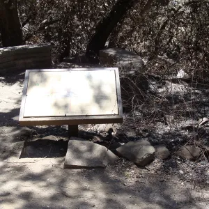 Fiber Arts Display sign, with spiral patio and circular stone bench, after the Jesusita Fire