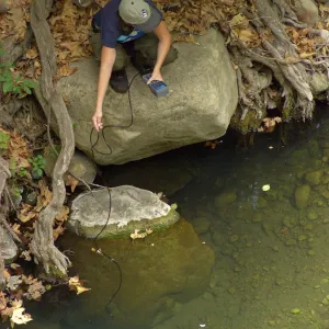 Steelhead trout release below Mission Dam. Gaytha Morningstar checks water temperature and oxygen content.