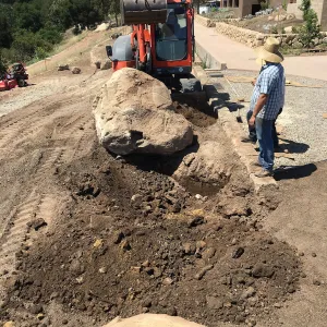 Moving boulder behind island sculpure into place. Island View Garden construction