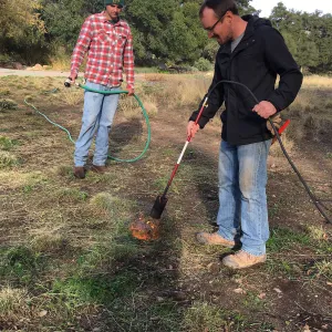Wes Franken and Nick Resler using a torch for weed abatement