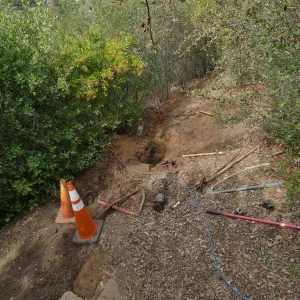 Site of broken 4 inch irrigation water pipe in Porter Trail section, looking from steps to parking lot.