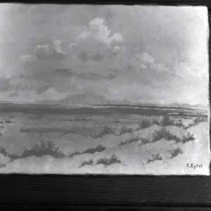 Black and white photograph of a painting of a desert landscape with the signature C Eytel taken against a door.