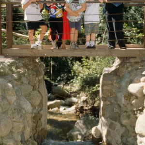 visitors stand on the foot bridge on the Mission Dam