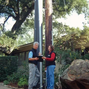 New power pole installed adjacent to the old wooden 'acorn granary' pole
