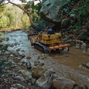 using a tractor to clear Mission Creek, above Mission Dam
