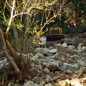 Mission Creek flooded above Mission Dam, with a bulldozer in background