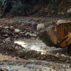 Mission Creek flooded above Mission Dam, with a bulldozer