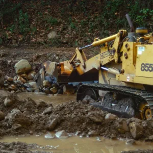 Mission Creek flooded above Mission Dam, with a bulldozer