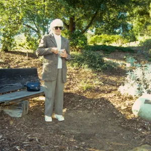 Ann Jones sowing wildflower seeds, Porter Trail, wood bench
